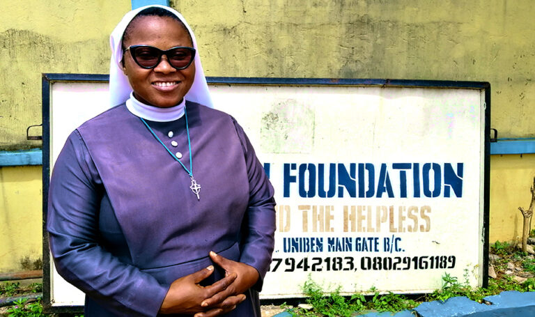 Sister Felicia stands by the Trinitarian orphanage signboard